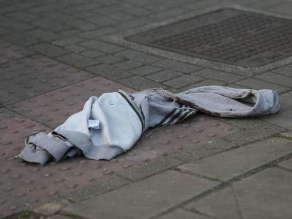 An item of clothing lies on the pavement at the junction of Palmerston Road and the High Street, in Wealdstone, in north-west London, after two boys, aged 12 and 15, were shot at two locations in close proximity