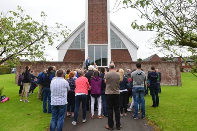 Members of the congregation gather outside the church after the arson attack in July 2016