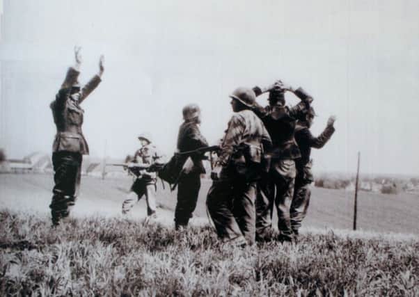Sgt Teddy Dixon (closest, side on with gun) helping capture SS guards fleeing Dachau concentration camp in April 1945