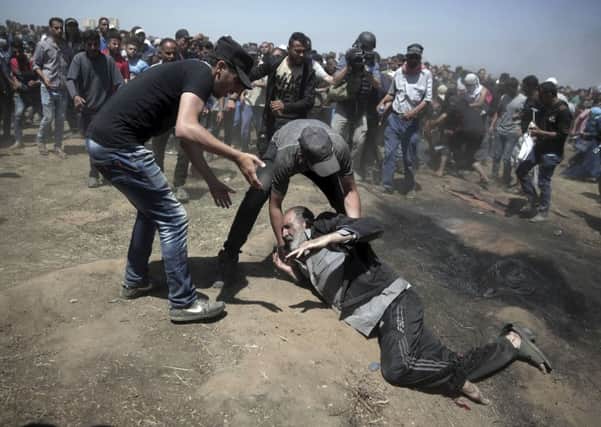 An elderly Palestinian man falls on the ground after being shot by Israeli troops during a deadly protest at the Gaza Strip's border with Israel