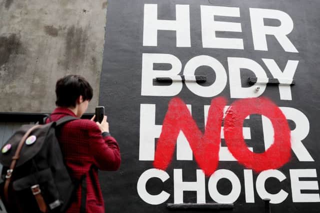 A woman takes a picture of a mural in Dublin's city centre by art group Subset calling for 'Repeal The 8th' ahead of the referendum on the 8th Amendment of the Irish Constitution on May 25th. PRESS ASSOCIATION Photo. Picture date: Tuesday May 22, 2018. See PA story IRISH Abortion. Photo credit should read: Brian Lawless/PA Wire