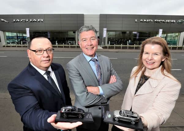 Charles Hurst head of business Norman Fraser, left, and group operations director Colin McNab with Christina Fickling, regional business manager for Jaguar Land Rover outside the brand new Boucher Road showroom