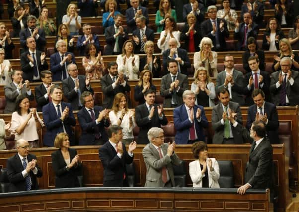 Spain's Prime Minister Mariano Rajoy, bottom right, waves as members of his party applaud him during a no confidence session at the Spanish parliament in Madrid, Friday, June 1, 2018. In his six years in office, Mr Rajoy displayed an unwavering commitment to reducing the national debt (AP Photo/Francisco Seco)
