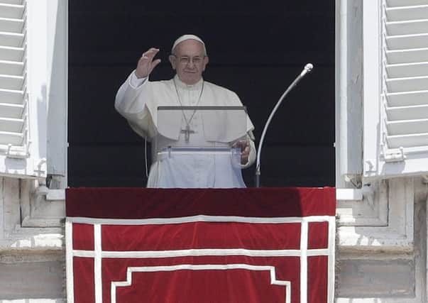 Pope Francis waves to the faithful during the Angelus noon prayer in St Peters Square at the Vatican yesterday