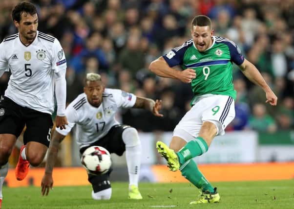 Northern Ireland's Conor Washington with Germany's Mats Hummels and Jerome Boateng during the qualifier at Windsor Park in October 2017