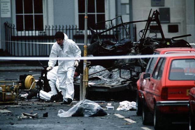 A forensics officer surveys the scene of devastation at Market Place in Lisburn after the IRA bomb that killed six soldiers. Pic by Pacemaker
