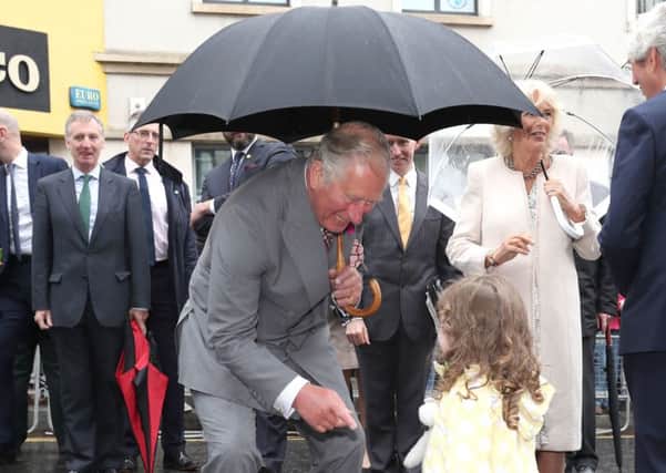 The Prince of Wales and the Duchess of Cornwall receive a toy for Prince Louis from Matilda Callahan of Dromore, during a walk about in Omagh town centre, as part of their tour of Northern Ireland. PRESS ASSOCIATION