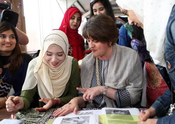 DUP leader Arlene Foster gets a henna design from Syifaa Nabir during her visit to S13 organised by the Belfast Islamic Centre. Pic by Freddie Parkinson, Press Eye
