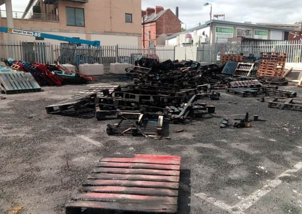 The remains of around 30 pallets that were set alight at the Sandy Row bonfire site on the morning of 18 June 2018