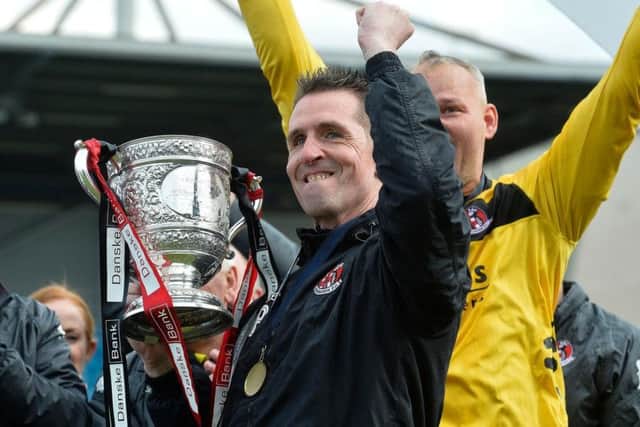 Crusaders manager Stephen Baxter celebrates with last season's Danske Bank Premiership title trophy.