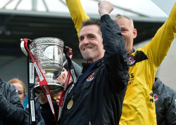 Crusaders manager Stephen Baxter celebrates with last season's Danske Bank Premiership title trophy.