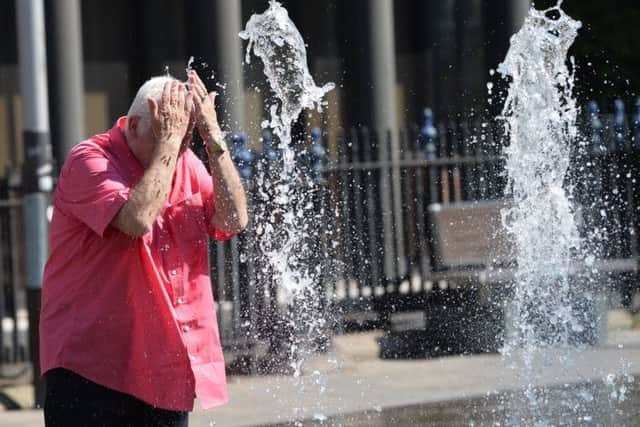 Cooling down at the water fountain during the hot weather in Belfast. Pic by Colm Lenaghan/Pacemaker