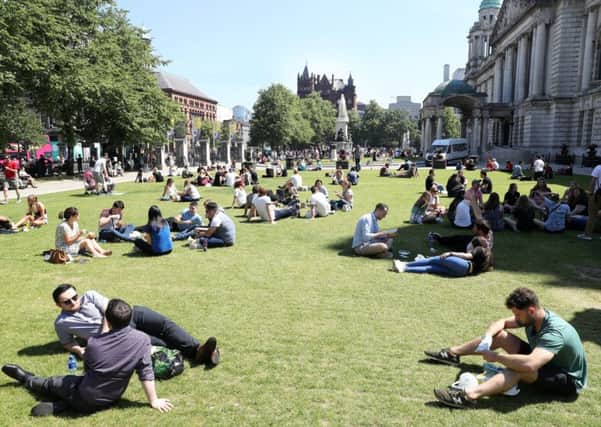 In the heart of the city, people enjoy sunshine in the grounds of Belfast City Hall on Wednesday June 29, one of the days when temperatures in Northern Ireland hit 30 degrees Celsius (86 Fahrenheit)