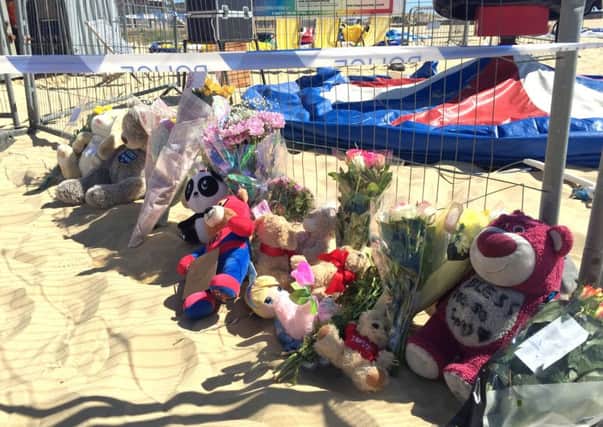 Floral tributes left at Gorleston beach in Norfolk where a girl was fatally thrown from an inflatable 
on Sunday, as an MP calls for bouncy castles to be temporarily banned in public areas