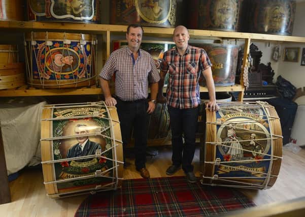 Lambeg manufacturer David Alexander from Markethill with News Letter journalist Graeme Cousins, who is pictured inset trying (without much success) to master the art of playing the Lambeg drum. Picture by Arthur Allison / Pacemaker Press