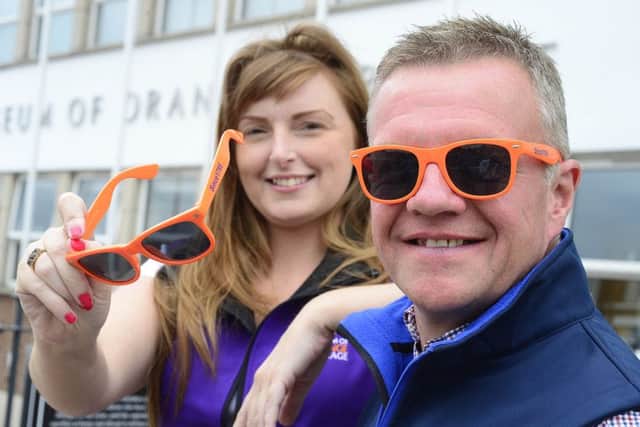 David Scott, who runs the Schomberg House shop, and service officer Coleen Large show off the Orange-branded sunglasses