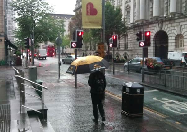 Rain returns: The dull, damp scene in Belfast city centre on Wednesday morning.