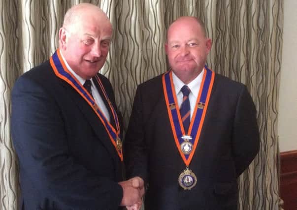 John Morrow, imperial grand master (right), is congratulated by Edward Stevenson, grand master of the Grand Orange Lodge of Ireland, following his election at this month's Imperial Orange Council in Scotland