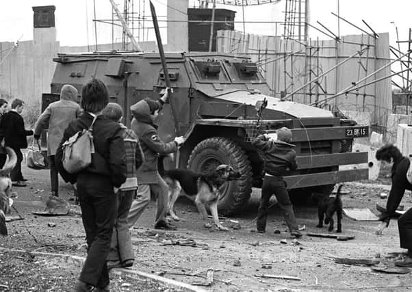 Youths bombarding an Army Saracen at a junction on the Whiterock Road in Belfast in 1980. The soldiers inside ignored the children