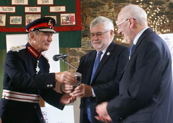 Lord Lieutenant of Co Down David Lindsay Presentng QAVS to club chairman Trevor McBurney. Founding member Alfie Braden on right