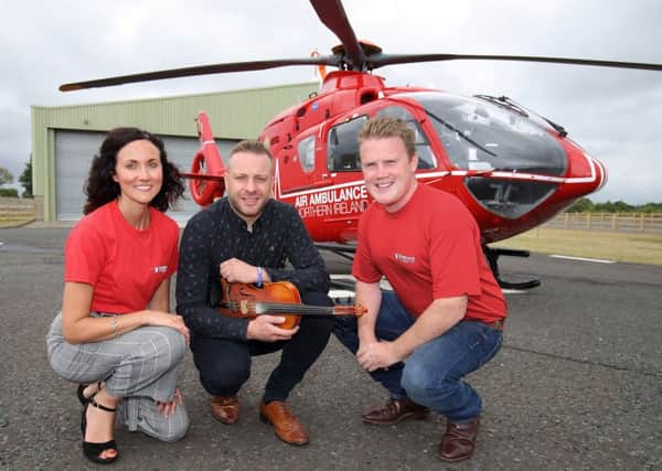 James Speers, YFCU president, and Kerry Anderson from Air Ambulance NI are pictured with Ritchie Remo, headline act for the presidents fundraising barn dance and barbecue for Air Ambulance NI