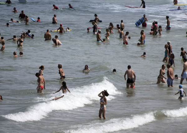 People enjoy the sea at Biarritz beach, southwestern France, Wednesday, July 25, 2018, which reached 26 Celsius (79F), as the hot weather continues across the country. (AP Photo/Bob Edme)