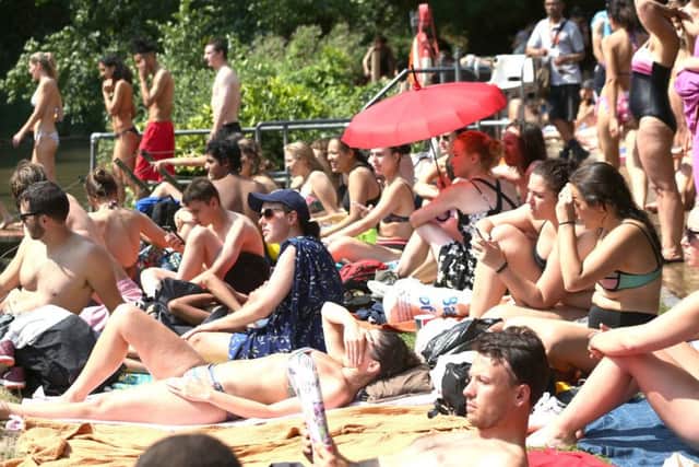 People sunbathing at the mixed bathing pond on Hampstead Heath, London on Thursday. Photo: Yui Mok/PA Wire