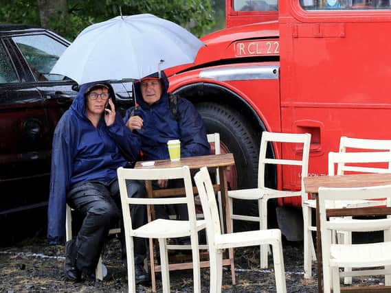 Fans take shelter from the rain at the Armoy Road Races on Saturday.