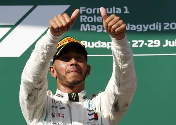 Mercedes driver Lewis Hamilton of Britain celebrates on the podium after winning the Hungarian Formula One Grand Prix