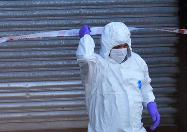 A police forensics investigator at the garage on the Moor Road in Coalisland where the torture and manslaughter took place