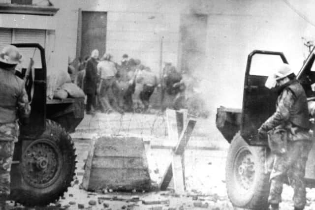 Soldiers take cover behind armoured cars in Londonderry in January 1972