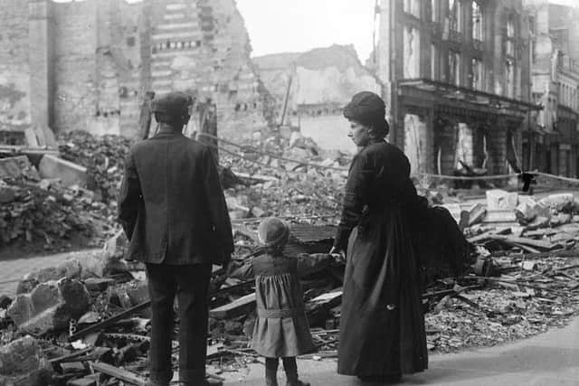 A refugee family returning to Amiens, looking at the ruins of a house, September 17, 1918.Ã½ IWM (Q 11341)