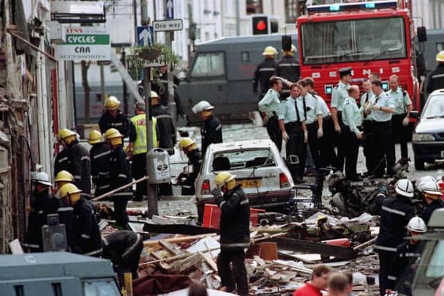 File photo dated 15/08/1998 of police officers and firefighters inspecting the damage caused by a bomb explosion in Market Street, Omagh