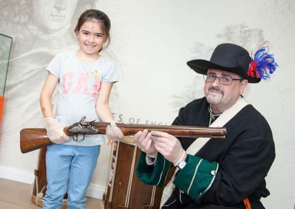 Kailey Laing with museum curator Dr Jonathan Mattison holding a 17th century musket believed to have been used in the Battle of the Boyne at last year's event, held at the Museum of Orange Heritage, Belfast