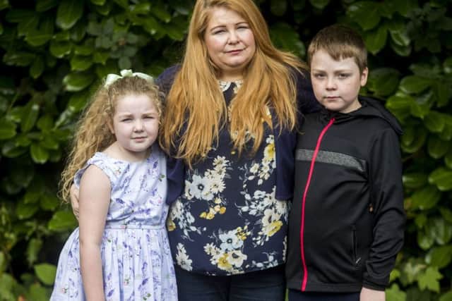 Cat Wilkinson, daughter of Michael Gallagher, with her daughter Fara, aged 8 and son Fynn, aged 10, outside the offices of Omagh Support & Self Help Group. Her brother 21-year-old Aiden Gallagher, who was killed in the Omagh bomb, had been preparing to emigrate to the United States