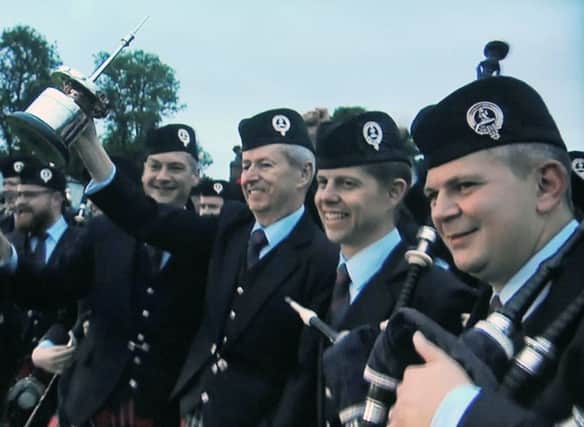 Pipe Major Richard Parkes lifts the RSPBA Jubilee Trophy as Field Marshal Montgomery are crowned grade one world champions