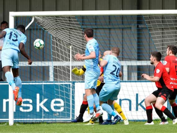 Maxim Kouogun heads home the opening goal between Warrenpoint Town and Crusaders.