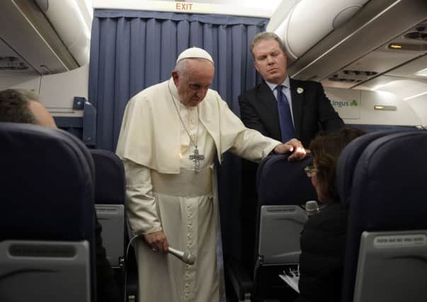 Pope Francis, flanked by Vatican spokesperson Greg Burke, listens to a journalist's question during a press conference aboard of the flight to Rome at the end of his two-day visit to Ireland, Sunday, Aug. 26, 2018. (AP Photo/Gregorio Borgia, Pool)