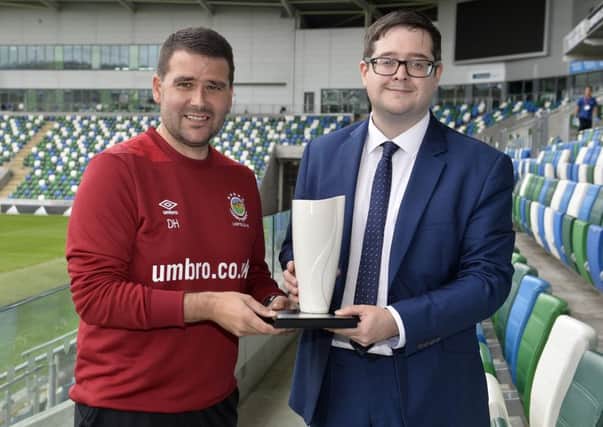 Linfield manager David Healy (left) collects his award from NIFWA chairman Keith Bailie.