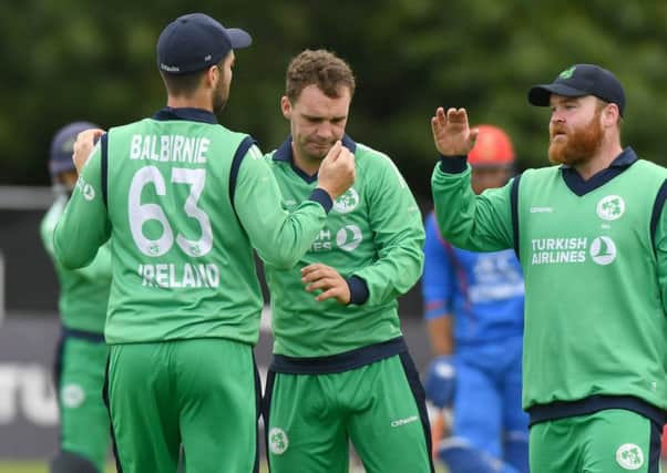 Ireland's ndrew Balbirnie is congratulated by Paul Stirling after catching Rahmat Shah off the bowling of Andy McBrine (centre).