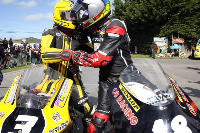 Paul Robinson is congratulated by Gary Dunlop after they finished first and second respectively in the Moto3/125 race at Killalane.