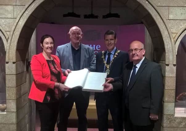 Roisin Doherty, curator, Museum Services, DCSDC, handing over a copy of the 1688-1704 Common Council Minutes which will be going on display at the Siege Museum. Included are Billy Moore, Siege Museum, Mayor of Derry City and Strabane District Council John Boyle and Lord Hay of Ballyore.