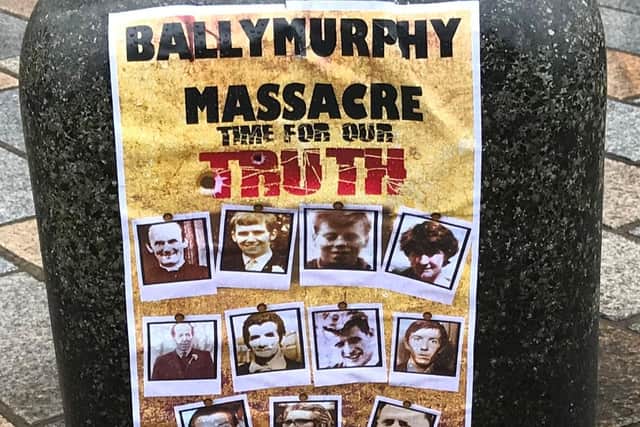 A poster featuring photos of those killed in the Ballymurphy massacre outside the Royal Courts of Justice, Belfast, where a preliminary hearing is being held for the inquest into their deaths.
