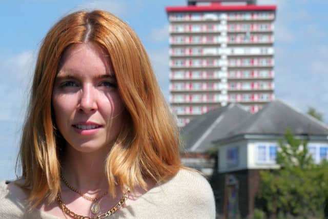 Stacey Dooley pictured in Belfast with Divis Tower in the background background. Stacey Dooley - (C) BBC - Photographer: Joseph McAuley