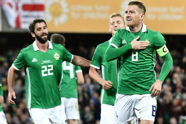 Northern Ireland skipper Steven Davis wheels away in celebration after he opened the scoring in Tuesday night's 3-0 win over Israel at Windsor Park.