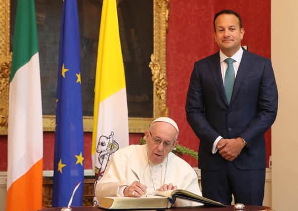 Pope Francis signs the arrivals book as he meets with Taoiseach Leo Varadkar at Dublin Castle as part of his visit to Ireland in August.  Photo: Niall Carson/PA Wire