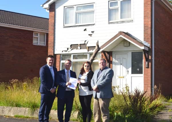 Resident Sophie Bagguley hands over the petition to Sir Jeffrey Donaldson MP, Cllr Scott Carson (left) and Cllr Jonathan Craig (right) outside one of the former MoD houses in the Mountview area of Lisburn.