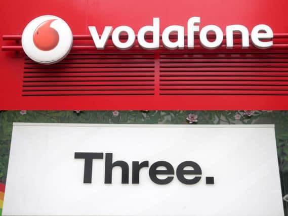 Undated file photos of the logos for mobile phone networks Vodafone and Three