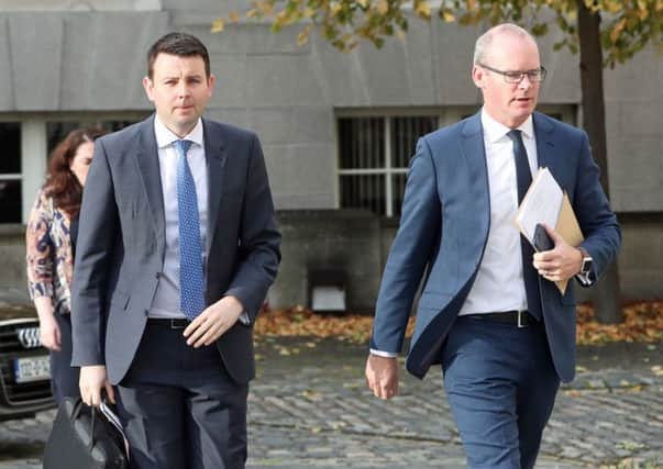 The Republics foreign minister Simon Coveney (right) with press advisor Chris Donoghue, in Dublin yesterday