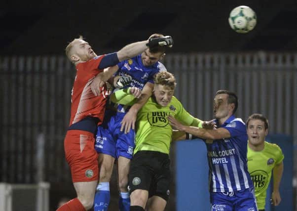 Newry's Declan Carville in action with Warrenpoint's Aaron Carey
.